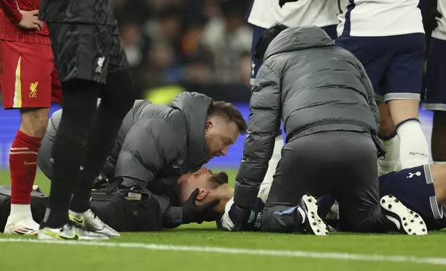 Tottenham's Rodrigo Bentancur receives medical treatment during the English League Cup semi final first leg soccer match between Tottenham and Liverpool, at the Tottenham Hotspur Stadium in London, Wednesday, Jan. 8, 2025. (AP Photo/Ian Walton)