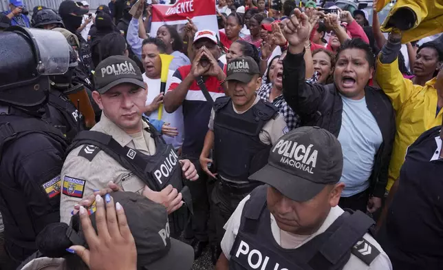 Protesters shout as lawyers enter court for a hearing for the soldiers accused of being connected to the disappearance of four children in Guayaquil, Ecuador, Tuesday, Dec. 31, 2024. (AP Photo/Cesar Munoz)