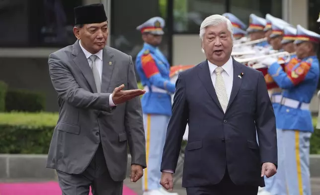 Japan's Defense Minister Gen Nakatani, right, is shown the the way by his Indonesian counterpart Sjafrie Sjamsoeddin as they inspect honor guards during a welcoming ceremony prior to their meeting in Jakarta, Indonesia, Tuesday, Jan. 7, 2025. (AP Photo/Achmad Ibrahim)