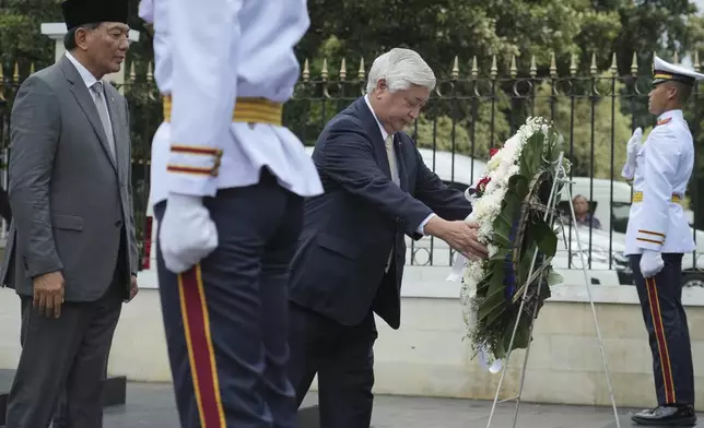 Japan's Defense Minister Gen Nakatani, center, lays a wreath as his Indonesian counterpart Sjafrie Sjamsoeddin, left, looks on during a welcoming ceremony prior to their meeting in Jakarta, Indonesia, Tuesday, Jan. 7, 2025. (AP Photo/Achmad Ibrahim)