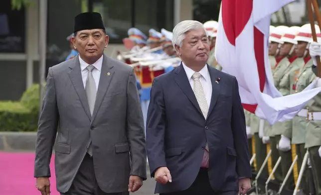 Japan's Defense Minister Gen Nakatani, right, walks with his Indonesian counterpart Sjafrie Sjamsoeddin as they inspect honor guards during a welcoming ceremony prior to their meeting in Jakarta, Indonesia, Tuesday, Jan. 7, 2025. (AP Photo/Achmad Ibrahim)