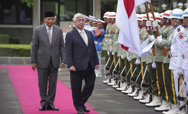 Japan's Defense Minister Gen Nakatani, right, walks with his Indonesian counterpart Sjafrie Sjamsoeddin as they inspect honor guards during a welcoming ceremony prior to their meeting in Jakarta, Indonesia, Tuesday, Jan. 7, 2025. (AP Photo/Achmad Ibrahim)