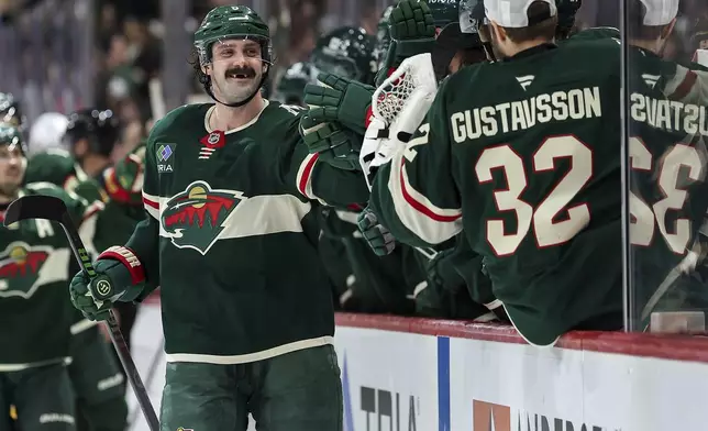 Minnesota Wild defenseman Jake Middleton is congratulated for his goal during the third period of an NHL hockey game against the St. Louis Blues, Tuesday, Jan. 7, 2025, in St. Paul, Minn. (AP Photo/Matt Krohn)