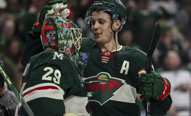 Minnesota Wild goaltender Marc-Andre Fleury, left, and center Joel Eriksson Ek celebrate their teams win after an NHL hockey game against the St. Louis Blues, Tuesday, Jan. 7, 2025, in St. Paul, Minn. (AP Photo/Matt Krohn)