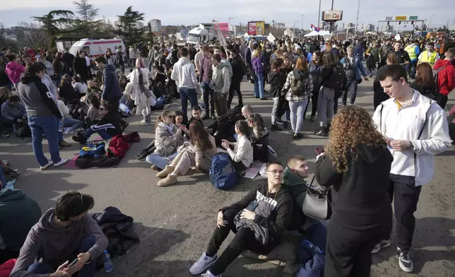 Students rest during a student-led 24 hour block on an intersection to protest the deaths of 15 people killed in the November collapse of a train station canopy, in Belgrade, Serbia, Monday, Jan. 27, 2025. (AP Photo/Darko Vojinovic)