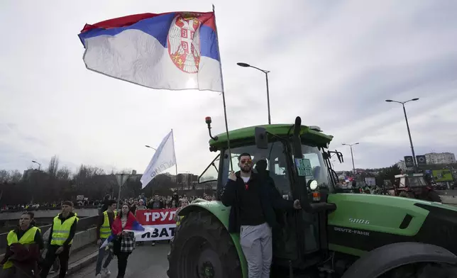 Farmers drive agricultural tractors during a student-led 24 hour block on an intersection to protest the deaths of 15 people killed in the November collapse of a train station canopy, in Belgrade, Serbia, Monday, Jan. 27, 2025. (AP Photo/Darko Vojinovic)