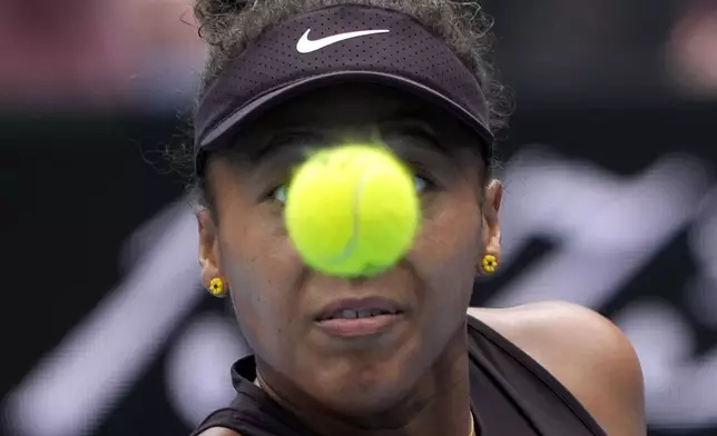 Naomi Osaka of Japan plays a backhand return to Karolina Muchova of the Czech Republic during their second round match at the Australian Open tennis championship in Melbourne, Australia, Wednesday, Jan. 15, 2025. (AP Photo/Asanka Brendon Ratnayake)