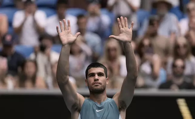 Carlos Alcaraz of Spain waves after defeating Yoshihito Nishioka of Japan in their second round match at the Australian Open tennis championship in Melbourne, Australia, Wednesday, Jan. 15, 2025. (AP Photo/Ng Han Guan)