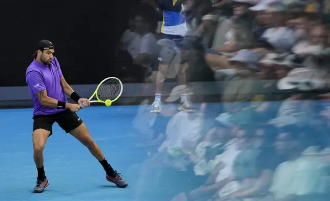 Matteo Berrettini of Italy plays a backhand return to Holger Rune of Denmark during their second round match at the Australian Open tennis championship in Melbourne, Australia, Thursday, Jan. 16, 2025. (AP Photo/Vincent Thian)