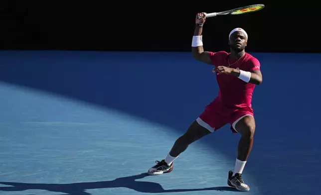 Frances Tiafoe of the U.S. plays a forehand return to Fabian Marozsan of Hungary during their second round match at the Australian Open tennis championship in Melbourne, Australia, Thursday, Jan. 16, 2025. (AP Photo/Vincent Thian)