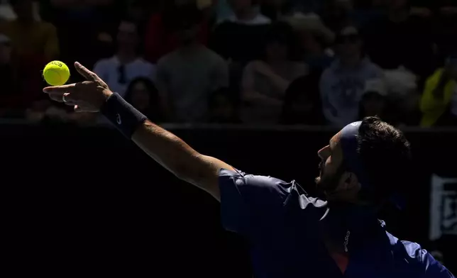 Lorenzo Musetti of Italy serves to Denis Shapovalov of Canada during their second round match at the Australian Open tennis championship in Melbourne, Australia, Thursday, Jan. 16, 2025. (AP Photo/Manish Swarup)