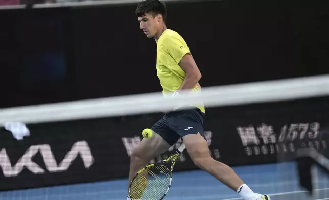Fabian Marozsan of Hungary plays a shot between his legs to Frances Tiafoe of the U.S. during their second round match at the Australian Open tennis championship in Melbourne, Australia, Thursday, Jan. 16, 2025. (AP Photo/Ng Han Guan)