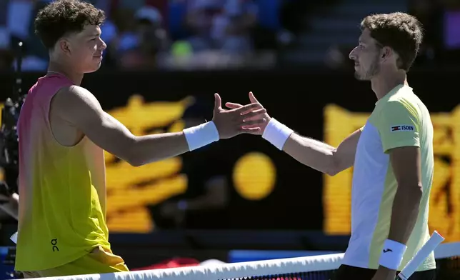 Ben Shelton, left, of the U.S. is congratulated by Pablo Carreno Busta of Spain following their second round match at the Australian Open tennis championship in Melbourne, Australia, Thursday, Jan. 16, 2025. (AP Photo/Vincent Thian)