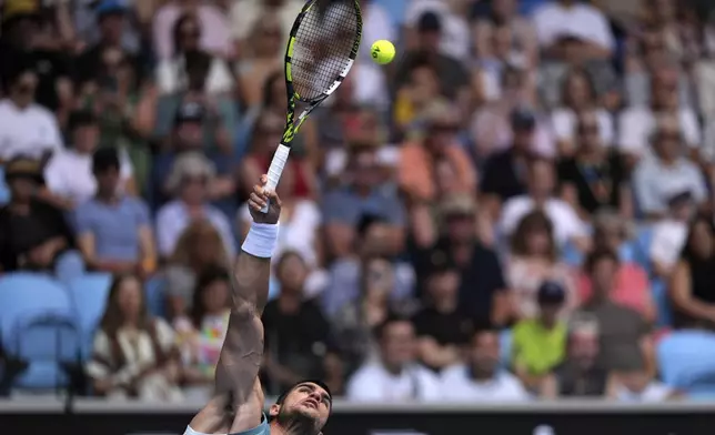 Carlos Alcaraz of Spain serves to Yoshihito Nishioka of Japan during their second round match at the Australian Open tennis championship in Melbourne, Australia, Wednesday, Jan. 15, 2025. (AP Photo/Ng Han Guan)