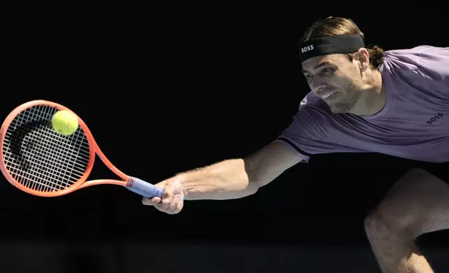 Taylor Fritz of the U.S. plays a forehand return to Cristian Garin of Chile during their second round match at the Australian Open tennis championship in Melbourne, Australia, Thursday, Jan. 16, 2025. (AP Photo/Ng Han Guan)