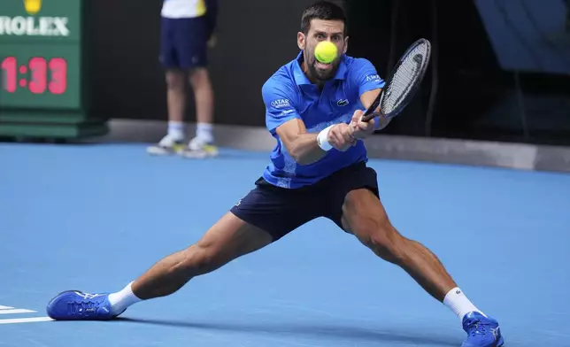 Novak Djokovic of Serbia plays a backhand return to Jaime Faria of Portugal during their second round match at the Australian Open tennis championship in Melbourne, Australia, Wednesday, Jan. 15, 2025. (AP Photo/Vincent Thian)