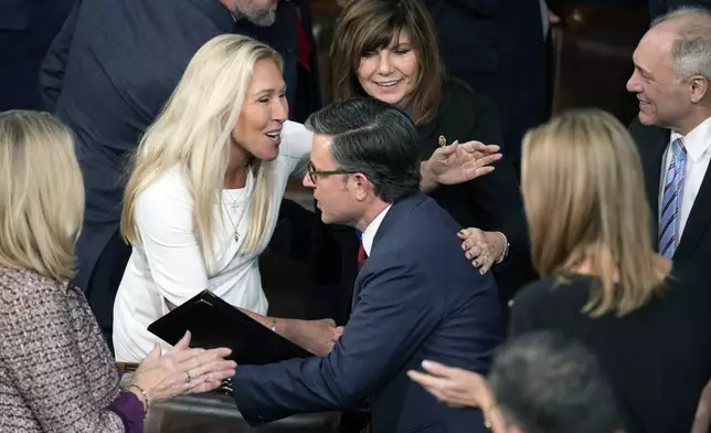 Speaker Mike Johnson, R-La., reenters the House Chamber after being re-elected Speaker as the House of Representatives convenes, and is greeted by Rep. Marjorie Taylor Greene, R-Ga., at the Capitol in Washington, Friday, Jan. 3, 2025. (AP Photo/J. Scott Applewhite)