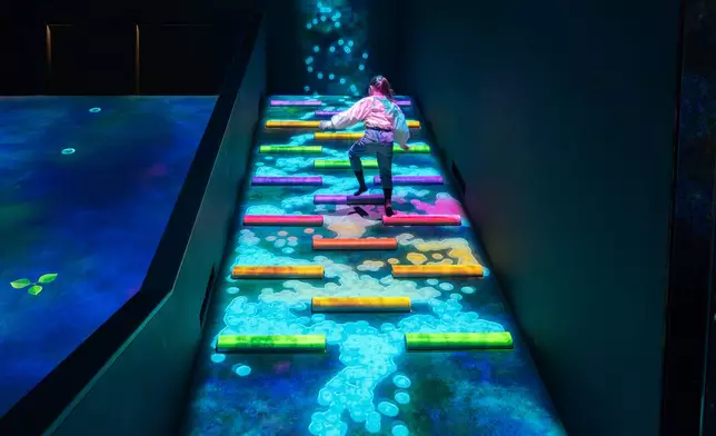 teamLab, Waterfall Droplets, Flowing Down a Slope (c) teamLab - Many water droplets flow down a slope. A single droplet bounces like a ball, but when many are gathered together, they behave like water. When they break apart, they behave like a ball again. When people climb the steps up the hill, the droplets near the step receive energy and break apart.