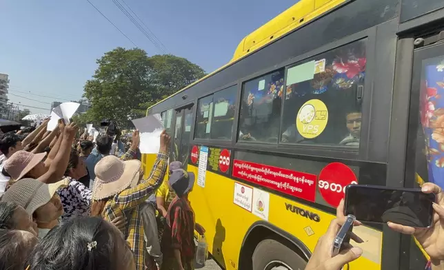 Released prisoners, in a bus, are welcomed by family members and colleagues after they left Insein Prison Saturday, Jan. 4, 2025, in Yangon, Myanmar. (AP Photo/Thein Zaw)