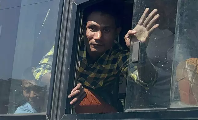 Released prisoners, in a bus, are welcomed by family members and colleagues after they left Insein Prison Saturday, Jan. 4, 2025, in Yangon, Myanmar, as the military government has released more than 6,000 prisoners and has reduced other inmates’ sentences as part of a mass amnesty to mark the 77th anniversary of independence from Britain.(AP Photo/Thein Zaw)