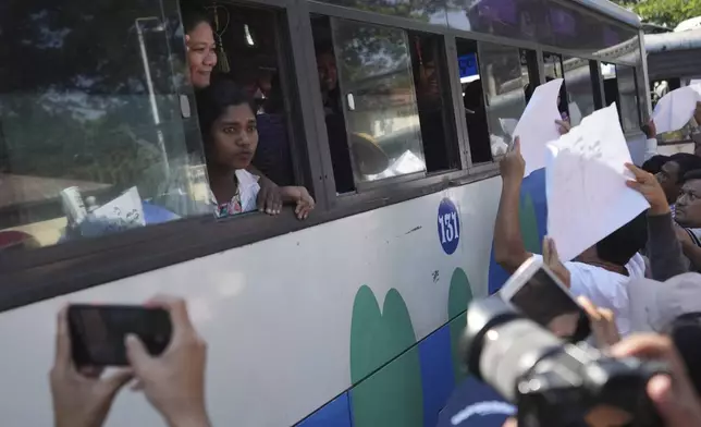 Released prisoners, in a bus, are welcomed by family members and colleagues after they left Insein Prison Saturday, Jan. 4, 2025, in Yangon, Myanmar, as the military government has released more than 6,000 prisoners and has reduced other inmates’ sentences as part of a mass amnesty to mark the 77th anniversary of independence from Britain. (AP Photo/Thein Zaw)