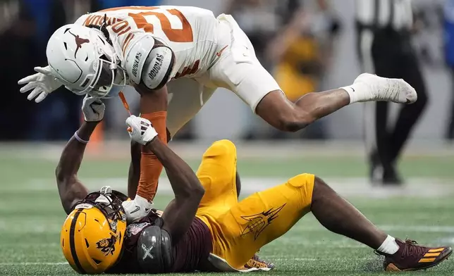 Arizona State wide receiver Melquan Stovall (5) and Texas defensive back Warren Roberson (24) collide during the first half in the quarterfinals of a College Football Playoff, Wednesday, Jan. 1, 2025, in Atlanta. (AP Photo/John Bazemore)