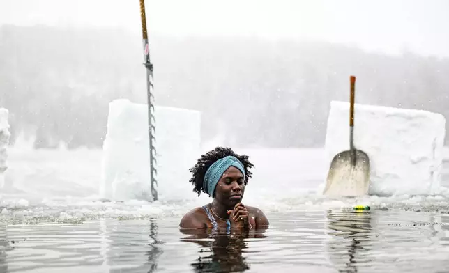 Canda-Leigh Habonimana dips in the waters of Gatineau Park's Meech Lake in Chelsea, Que., during a polar bear dip on New Year's Day, Wednesday, Jan. 1, 2025. (Justin Tang /The Canadian Press via AP)