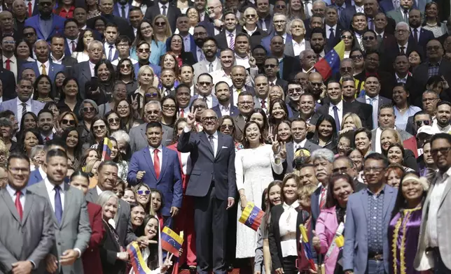 National Assembly President Jorge Rodriguez, center, poses for a photo with newly sworn-in lawmakers after the start of the legislative year in Caracas, Venezuela, Sunday, January 5, 2025. (AP Photo/Cristian Hernandez)