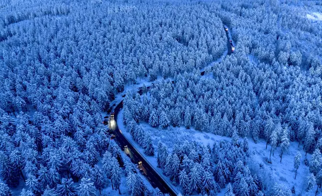 Cars drive up to the top of the Feldberg mountain near Frankfurt, Germany, Thursday evening, Jan. 2, 2025. (AP Photo/Michael Probst)