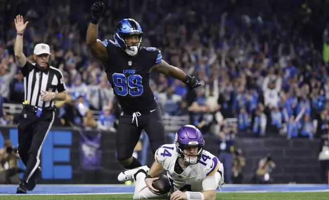 Minnesota Vikings quarterback Sam Darnold (14) is sacked by Detroit Lions defensive end Za'Darius Smith (99) during the first half of an NFL football game Sunday, Jan. 5, 2025, in Detroit. (AP Photo/Rey Del Rio)