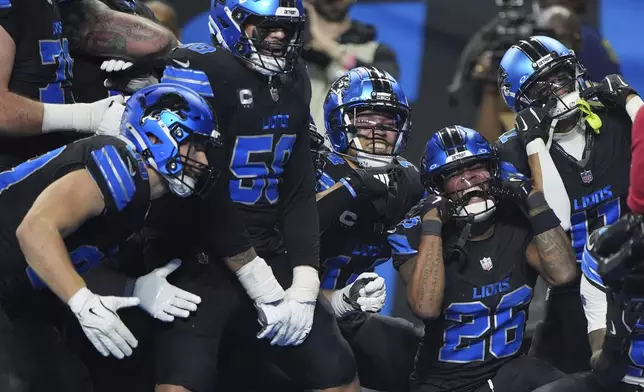 Detroit Lions running back Jahmyr Gibbs (26) celebrates with teammates after he ran for a touchdown against the Minnesota Vikings during the second half of an NFL football game Sunday, Jan. 5, 2025, in Detroit. (AP Photo/Charlie Riedel)