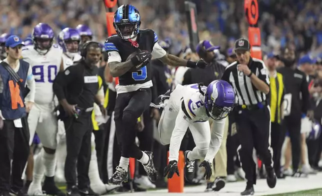 Detroit Lions wide receiver Jameson Williams (9) runs past Minnesota Vikings cornerback Stephon Gilmore (2) for a first down during the first half of an NFL football game Sunday, Jan. 5, 2025, in Detroit. (AP Photo/Charlie Riedel)