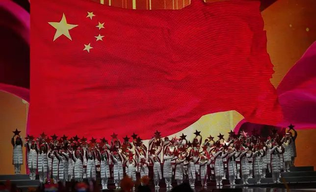 Performers prepare to ring in the new year near a Chinese national flag during a count down event held in Beijing, Tuesday, Dec. 31, 2024. (AP Photo/Ng Han Guan)