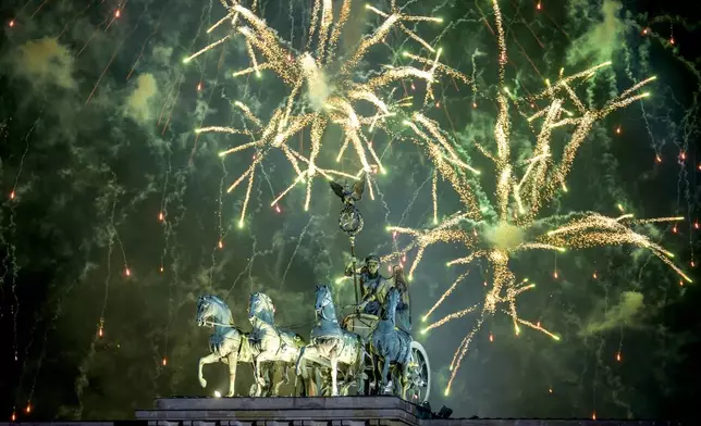 Fireworks light the sky above the Quadriga at the Brandenburg Gate during New Year's celebrations shortly after midnight in Berlin, Germany, Wednesday, Jan. 1, 2025. (AP Photo/Ebrahim Noroozi)