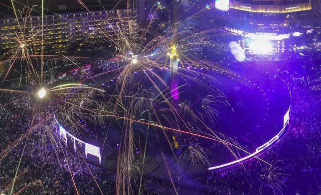 Fireworks explode as thousands of people gather in the main business district on New Year's Eve in Jakarta, Indonesia, Tuesday, Dec. 31, 2024. (AP Photo/Tatan Syuflana)