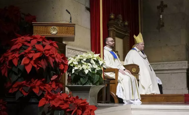 Archbishop Bernard Hebda, right, of Saint Paul and Minneapolis, celebrates a rare New Year’s Eve Mass attended just before midnight in St. Paul, Minn., on Dec. 31, 2024 (AP Photo/Giovanna Dell’Orto)