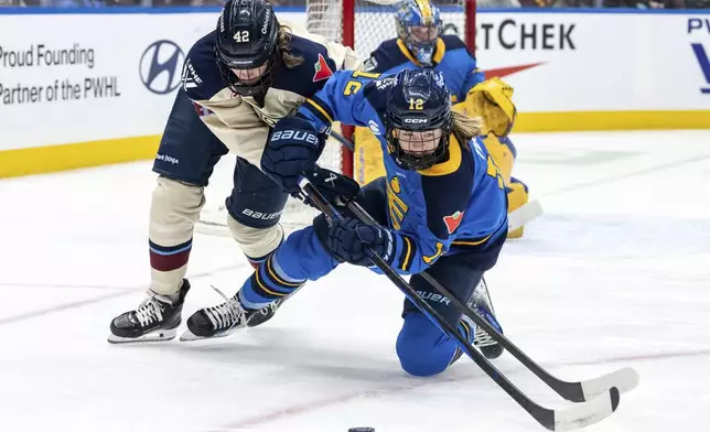 Montreal Victoire's Claire Dalton (42) and Toronto Sceptres' Allie Munroe (12) vie for the puck during first period PWHL hockey action in Vancouver, on Wednesday, January 8, 2025. (Ethan Cairns/The Canadian Press via AP)