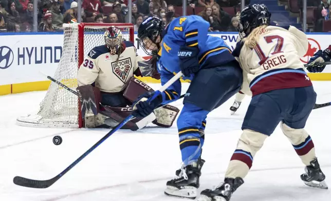 Montreal Victoire goaltender Ann-Renee Desbiens (35) watches as Toronto Sceptres' Renata Fast (14) and Montreal's Dara Greig (17) vie for the puck during second period PWHL hockey action in Vancouver, on Wednesday, January 8, 2025. (Ethan Cairns/The Canadian Press via AP)