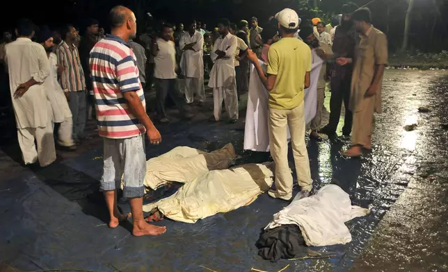 FILE - A team of local residents help the administration assist the relatives of the dead in identifying their family and friends at a civil hospital in Anandpur Sahib in Punjab, India, on Aug. 4, 2008. (AP Photo/Ashwini Bhatia, File)