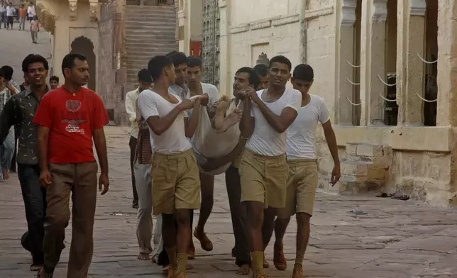 FILE - Volunteers carry a stampede victim in Jodhpur, India, Tuesday, Sept. 30, 2008. (AP Photo, File)