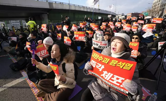 Protesters attend a rally demanding the arrest of impeached South Korean President Yoon Suk Yeol near the presidential residence in Seoul, South Korea, Wednesday, Jan. 8, 2025. The letters read "Arrest Yoon Suk Yeol." (AP Photo/Ahn Young-joon)