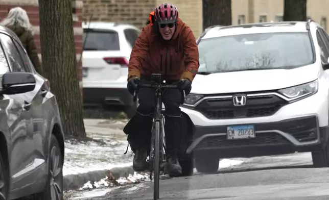 A man rides a bicycle during cold weather in Chicago, Wednesday, Jan. 8, 2025. (AP Photo/Nam Y. Huh)