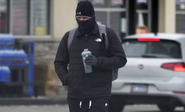 A pedestrian bundles up as he walks on the street during cold weather in Chicago, Wednesday, Jan. 8, 2025. (AP Photo/Nam Y. Huh)