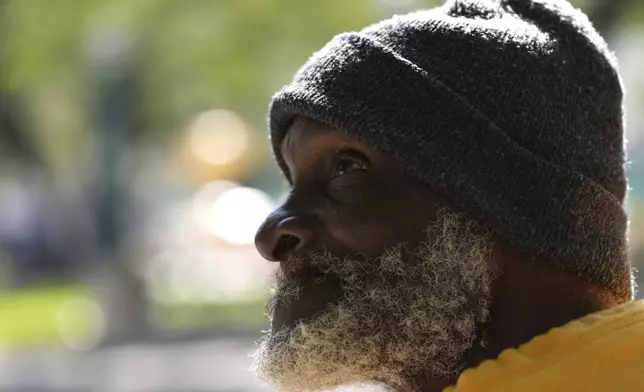 Willie Barnes, 63, who is homeless, talks with a homeless outreach advocate offering shelter as temperatures are forecast to be in the forties this evening Wednesday, Jan. 8, 2025, in Miami. (AP Photo/Lynne Sladky)