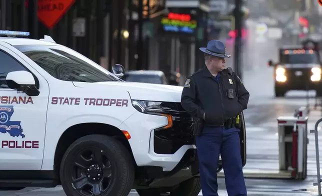 A state trooper stands by New Orleans' Canal and Bourbon streets, Thursday, Jan. 2, 2025. (AP Photo/George Walker IV)