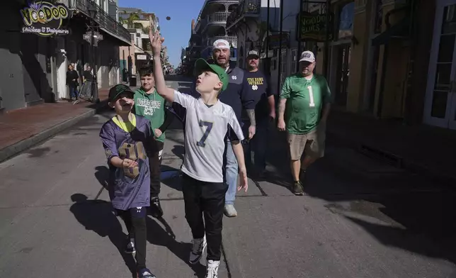 Cory Hunter flips a coin on Bourbon Street, Thursday, Jan. 2, 2025 in New Orleans. (AP Photo/George Walker IV)