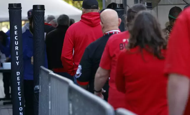 Fans pass through security check points as they enter the Superdome fan zone ahead of the Sugar Bowl NCAA College Football Playoff game, Thursday, Jan. 2, 2025, in New Orleans. (AP Photo/Butch Dill)