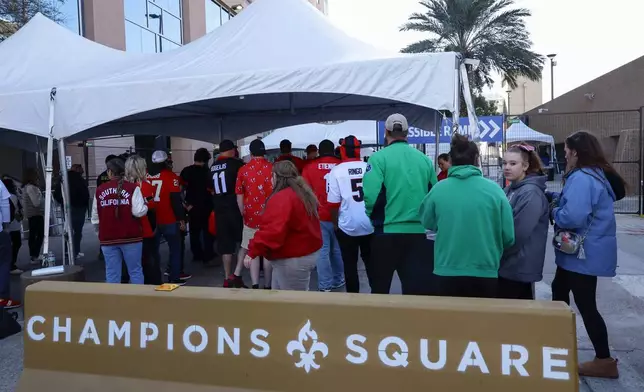 Fans pass through security check points as they enter the Superdome fan zone ahead of the Sugar Bowl NCAA College Football Playoff game, Thursday, Jan. 2, 2025, in New Orleans. (AP Photo/Butch Dill)