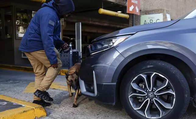 Security and bomb sniffing dogs check vehicles as they enter the Superdome parking garage ahead of the Sugar Bowl NCAA College Football Playoff game, Thursday, Jan. 2, 2025, in New Orleans. (AP Photo/Butch Dill)