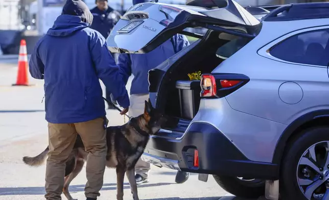 Security with bomb sniffing dogs check vehicles as they enter the Superdome ahead of the Sugar Bowl NCAA College Football Playoff game, Thursday, Jan. 2, 2025, in New Orleans. (AP Photo/Butch Dill)